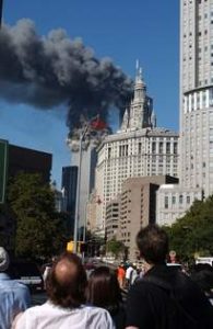 Crowd watches South Tower of the World Trade Center in Lower Manhattan collapsing as a result of terrorist attack on Sept. 11, 2001 at 9:59 a.m. photographed from Chatham Square near Chinatown. The upper structure can be seen in motion crumbling down. (Dan Howell Photo/Bigstock)